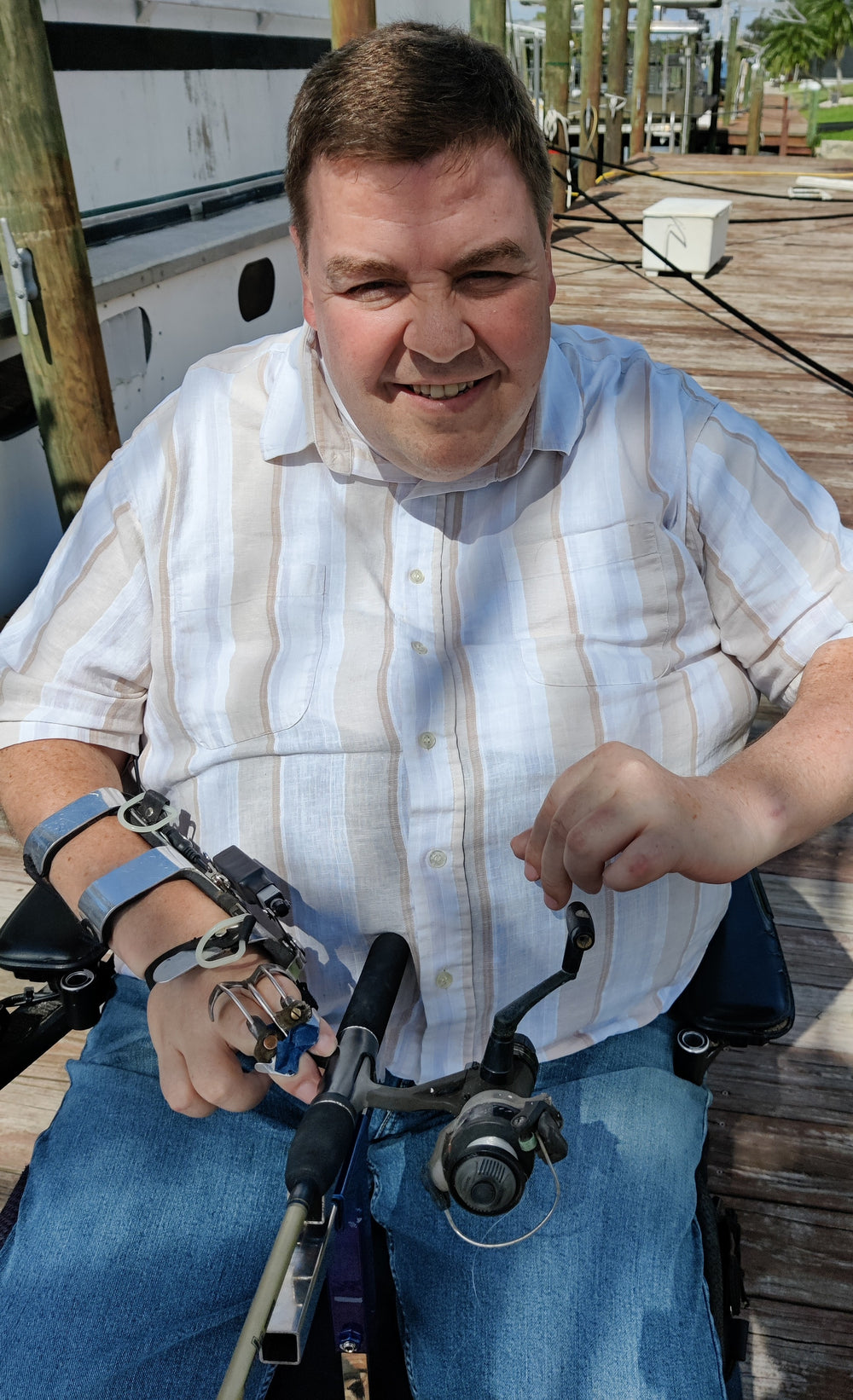 Hands-on wheelchair seat  adaptive fishing rod holder with manual reel-quadriplegic man Mark felling in wheelchair on dock